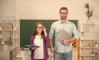 Özel öğretmen ve çocuk defterini tutuyor. Aile yardımı. Baba ve kızı defter kullanıyor..