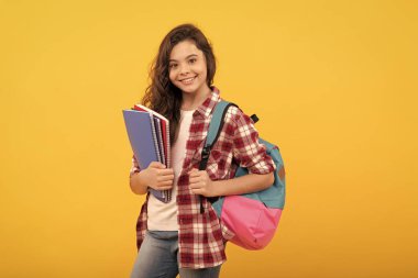 Lisede bir gün. Not defteri ve sırt çantası olan bir kız öğrenci. Okula dönüyorum. Genç kız çalışmaya hazır.