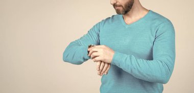 Kesilmiş adam zamanı kontrol ediyor. Kol saati olan adam. kopyalama alanı. Gelişigüzel giyinmiş bir adam..