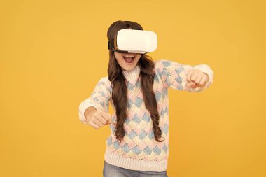 Mutlu genç kız kablosuz sanal gerçeklik gözlüğü takıyor. VR kulaklıkla. Çocuk video oyunu oynuyor. Dijital gelecek