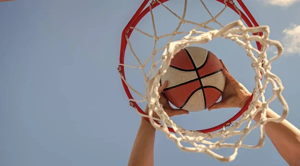 Pelota de baloncesto volando a través de la cesta en manos de los jugadores, copiar espacio, apuntar —  Fotos de Stock