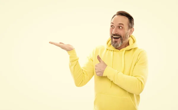 Man with beard and moustache in hoody presenting product on copy space isolated on white, thumb up. — Stock Fotó