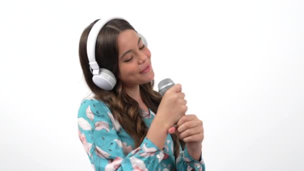 Talented happy teen girl singer listen music in headphones and sing karaoke in microphone, singing. — Stockvideo