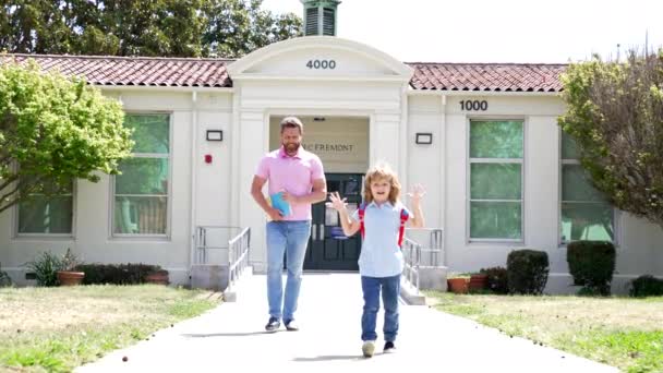 Веселий тато і дитина йдуть додому після школи, повільний рух, дитинство — стокове відео