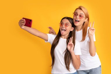 happy woman and girl take selfie with smartphone. selfie family. modern life. mobile technology