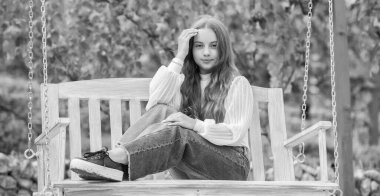 Neşeli çocuk parkta, parkta salıncakta oturuyor.