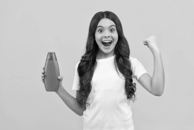 Uzun saçlı, şaşkın çocuk. Şampuan şişesi, deri.