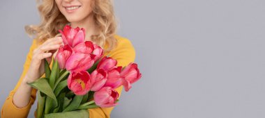 cropped smiling woman with tulips. lady hold flowers for spring holiday. girl with bouquet
