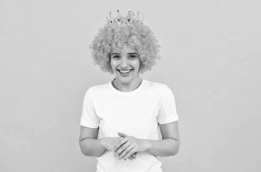 Kıvırcık palyaço peruğu ve kraliçe tacıyla parti için mutlu, bencil kadın, mutluluk.