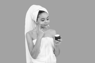 Güzel çocuk banyo kulesinde cilt kremi sürüyor, sağlıklı cilt.