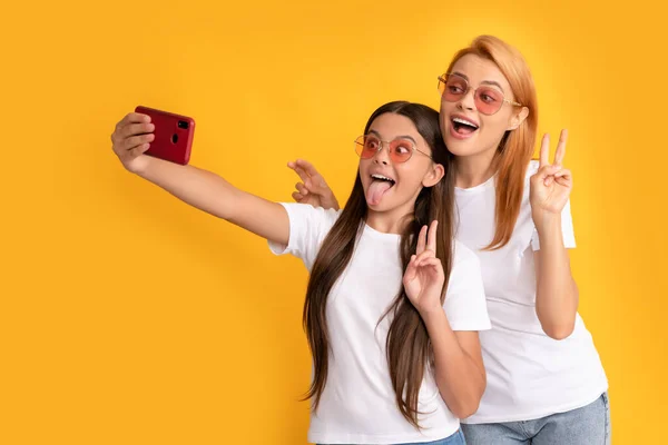 Happy woman and girl take selfie with smartphone. selfie family. modern life. mobile technology — Zdjęcie stockowe