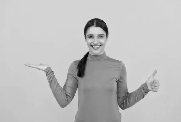 Mujer sorprendida retrato señalando los dedos en el espacio de copia fondo amarillo que muestra el pulgar hacia arriba, emociones —  Fotos de Stock