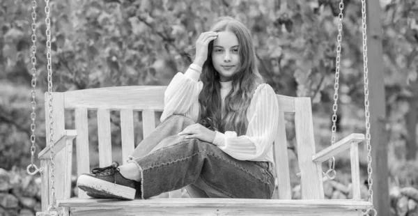 Neşeli çocuk parkta, parkta salıncakta oturuyor.