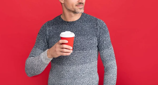 Vidám szürke fickó pulóverben, piros háttérrel. hoary férfi kávézás. — Stock Fotó