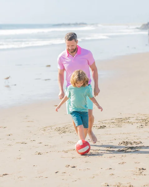 happy family of daddy man and child boy playing ball on beach, relationship