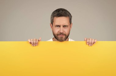 Sarı kağıdın arkasına sakallı, resimli, reklamlı olgun bir adam.