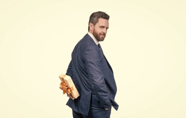 Takım elbiseli kendine güvenen bir işadamı hediye kutusunu beyazların arasında saklar ve sürpriz yapar.