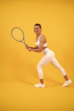 Spor giyim sektöründe raketle koşan mutlu genç kız. Sporcu kadın. Enerjik kadın.