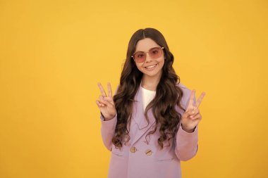 Olumlu duygularını ifade et. Güneş gözlüklü kıvırcık saçlı neşeli çocuk. güzellik ve moda.