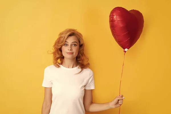 Elképedt vörös hajú lány szerelmes szív léggömbbel. jótékonyság és adomány — Stock Fotó