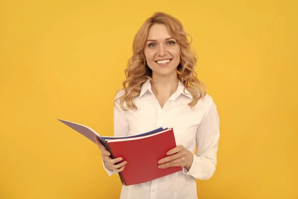 Boldog szőke üzletasszony nő fehér ingben jegyzeteket készít jegyzetfüzetben vagy jegyzetfüzetben, oktatás — Stock Fotó