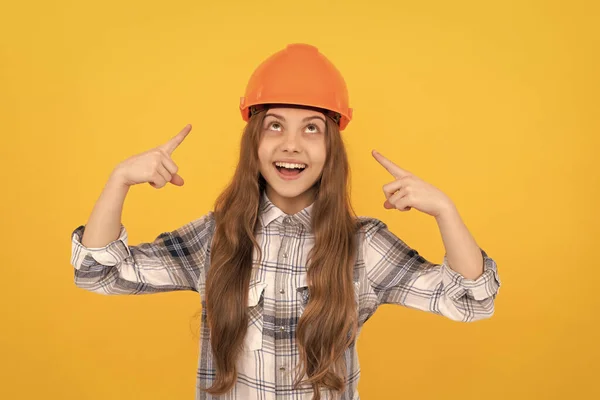 快乐的少女把手指放在头盔上，穿着格子衬衫，保护自己 — 图库照片