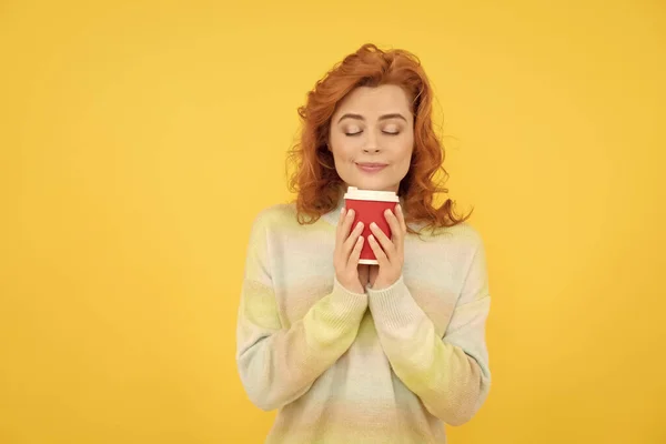 Mujer pelirroja feliz olor a café para llevar de la taza sobre fondo amarillo, buenos días — Foto de Stock