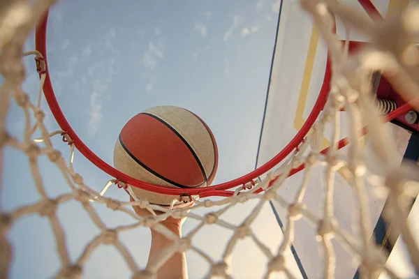 Hombre lanzando la pelota en el aro. manos y baloncesto. clavado en la cesta. slam dunk en movimiento — Foto de Stock