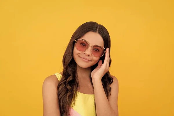 Enfant heureux dans des lunettes d'été a les cheveux bouclés sur fond jaune, beauté — Photo