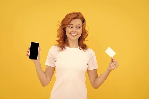 Mujer feliz mostrando tarjeta de crédito o débito y teléfono inteligente para hacer compras en línea, pago en línea. —  Fotos de Stock