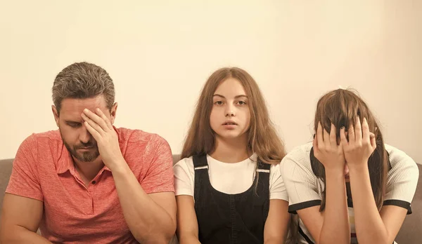 sad child between mother and father. family therapy. parents with kid having problems.