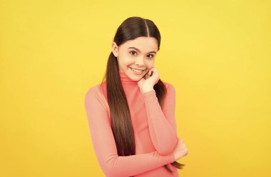 Sarı arka planda uzun saçlı mutlu çocuk, moda.