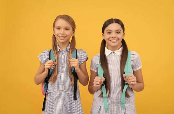 Niños felices de vuelta a la escuela en el Día del Conocimiento 1 de septiembre fondo amarillo, infancia —  Fotos de Stock