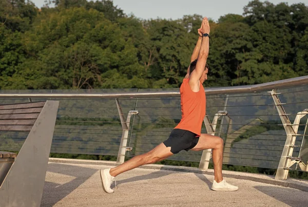 Fit man hold virabhadrasana pose doing crescent lunge stretch on promenade, yoga — Foto de Stock