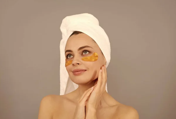 Få din hud att lysa. Kosmetologi. ung kvinna i frotté handduk använda patch. skönhet i spa. — Stockfoto