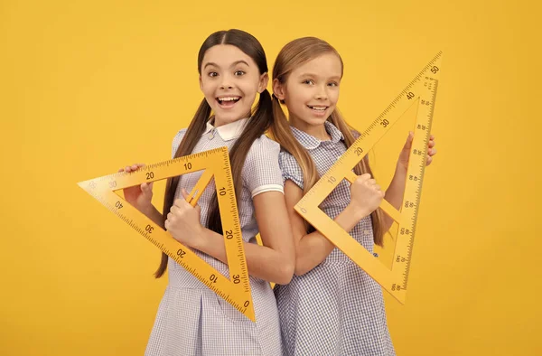 Educação para todas as crianças. Meninas adolescentes felizes segurar réguas triangulares. Educação escolar. Lição de geometria — Fotografia de Stock