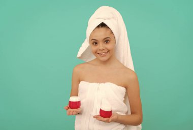 Gülümseyen genç kız banyo kulesinde sunar vücut estetiği, ten