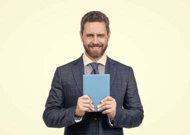 İş adamı gibi giyinmiş mutlu bir işadamı planlamacı beyazları izole edip, plan yapıyor.