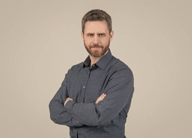 Sıradan tişörtlü sakallı adam kollarını çapraz tut kendine güven gri arka plan, rahat