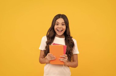 Şaşırmış okul çocuğu kitapla, bilgiyle çalışmaya hazır.