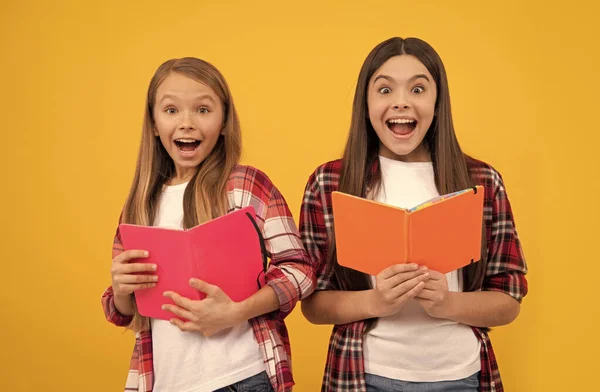 Здивовані діти в випадковій картатій сорочці мають веселі червоні книги, здивовані — стокове фото