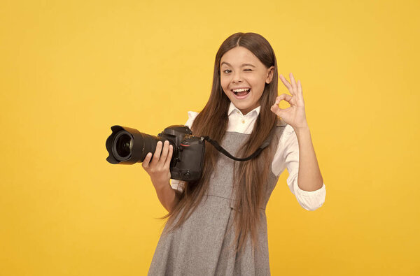 cheerful kid girl take photo with digicam show ok gesture, photography
