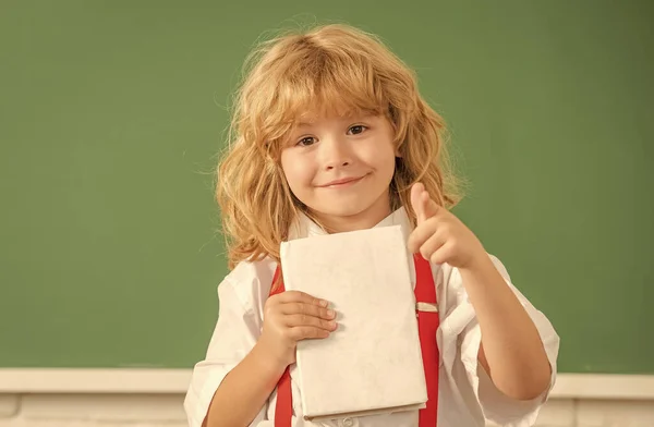 1. desarrollo de la infancia. niño con libro. Apunta. feliz adolescente chico en el aula. — Foto de Stock