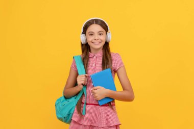 Mutlu çocukluk. Okul çantalı çocuk. Müzik. Mutlu genç kız sırt çantası taşıyor. Okula geri dön.