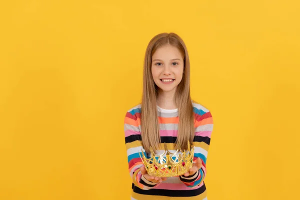 Feliz adolescente criança dar rainha coroa no fundo amarelo — Fotografia de Stock