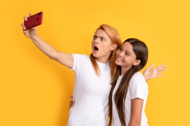 Neşeli anne ve çocuk akıllı telefondan selfie çekiyor, video çekiyor.