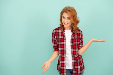 Mavi arka planda kareli tişörtlü, kırmızı saçlı kadını şaşırttı.