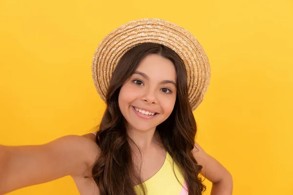 Happy kid in summer straw hat making selfie on yellow background, selfie time — Stockfoto