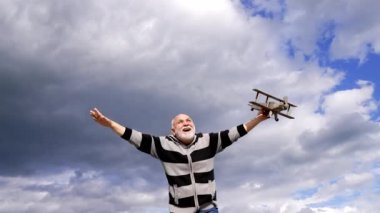 Mutlu kıdemli adam tahta uçakta uçuyormuş gibi yap, hayal kur.