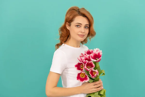 Positive girl with tulip flower bouquet on blue background — Stok fotoğraf